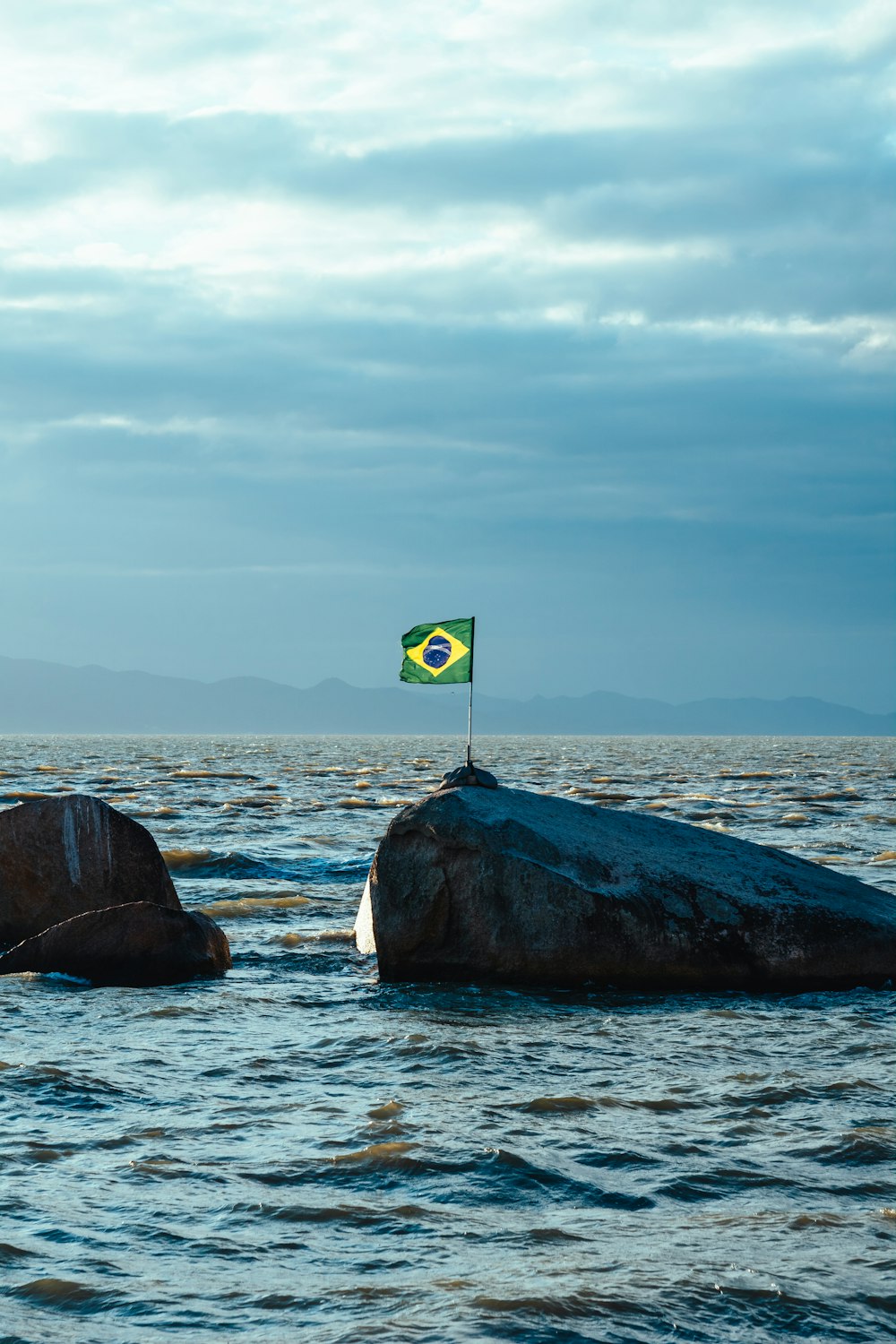 a flag on a rock in the water