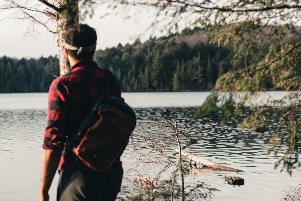 a man standing on a rock looking at a lake