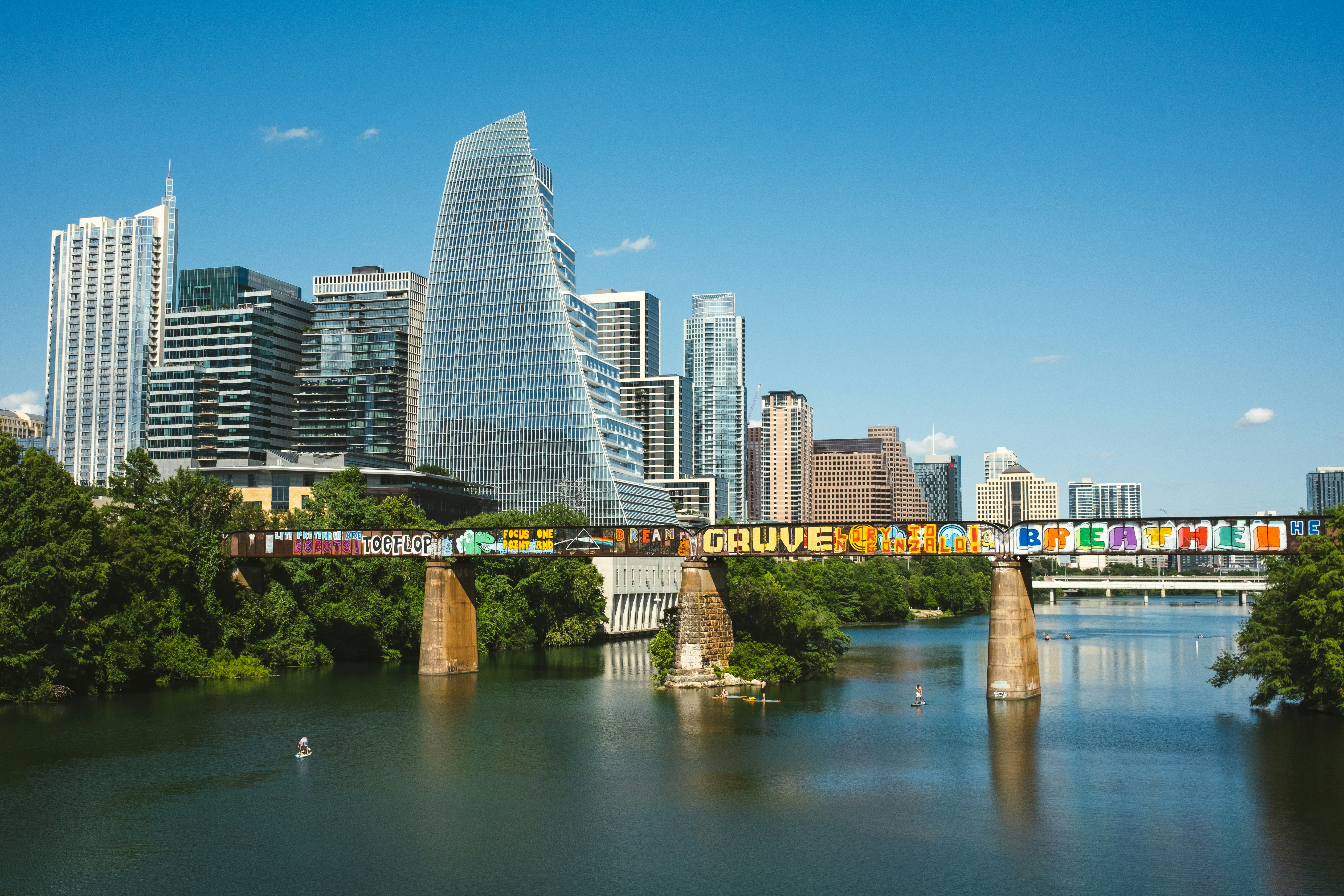 a city skyline with a bridge over a river