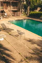 a pool with chairs and a table by it