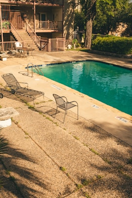 a pool with chairs and a table by it