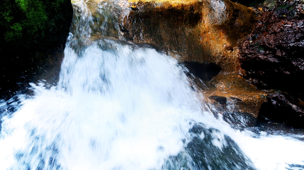 a waterfall with rocks and trees