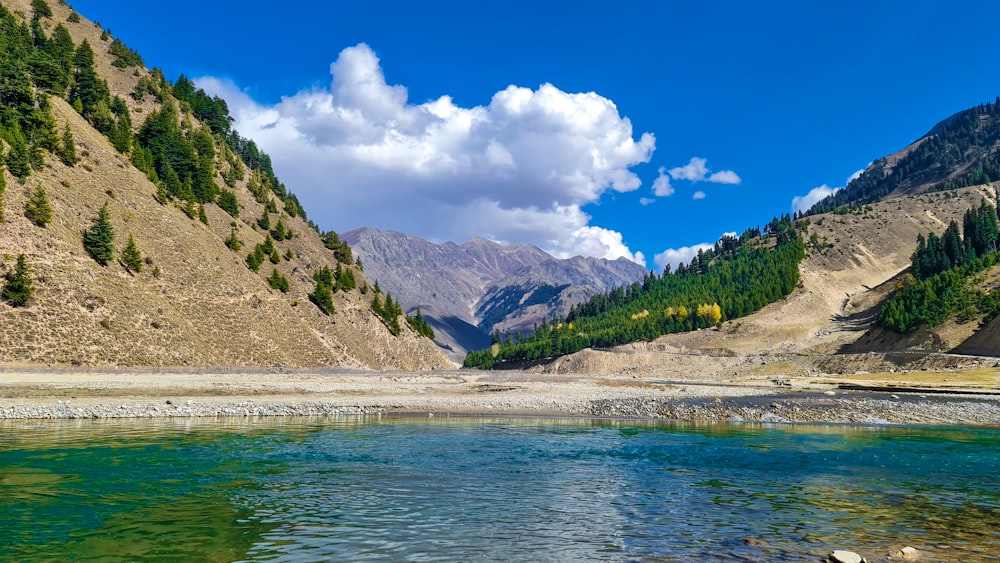 a body of water with mountains in the back