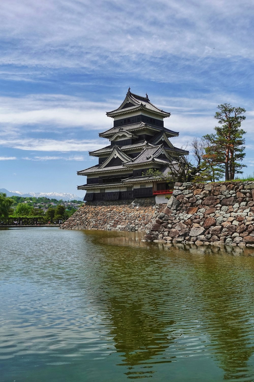 a building on a rock wall by water