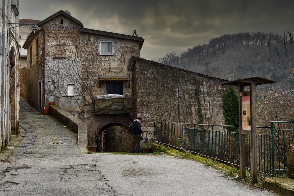 a person standing in a stone alleyway between stone buildings