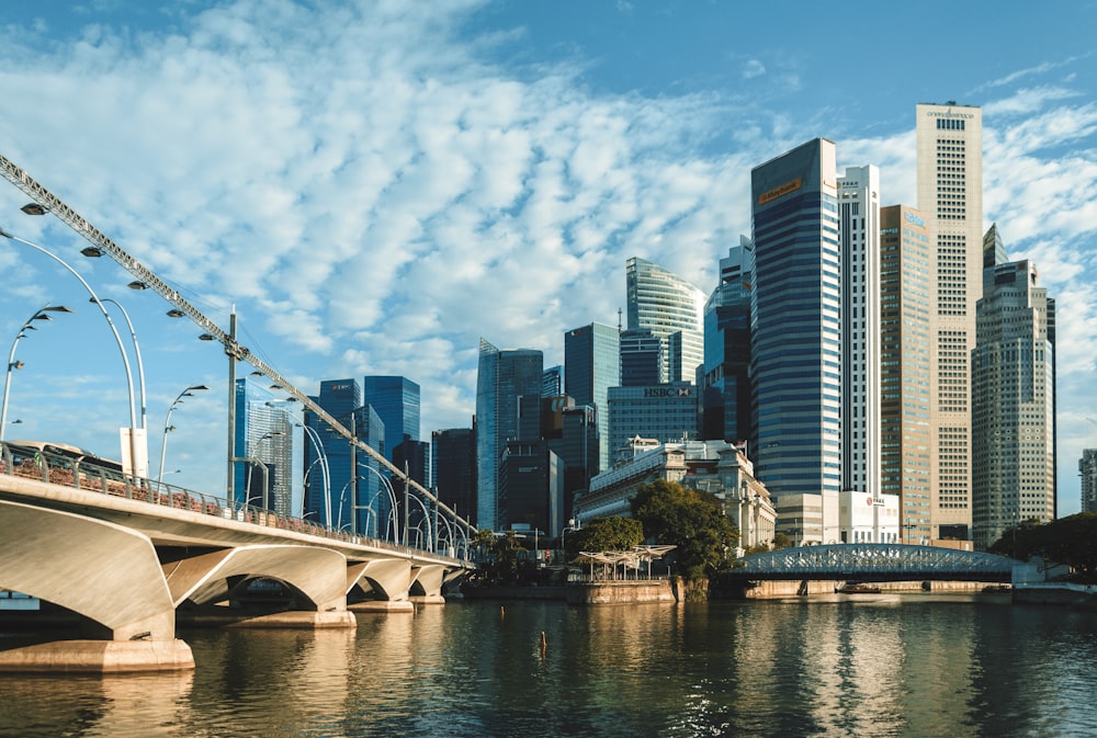 a bridge over water with a city in the background