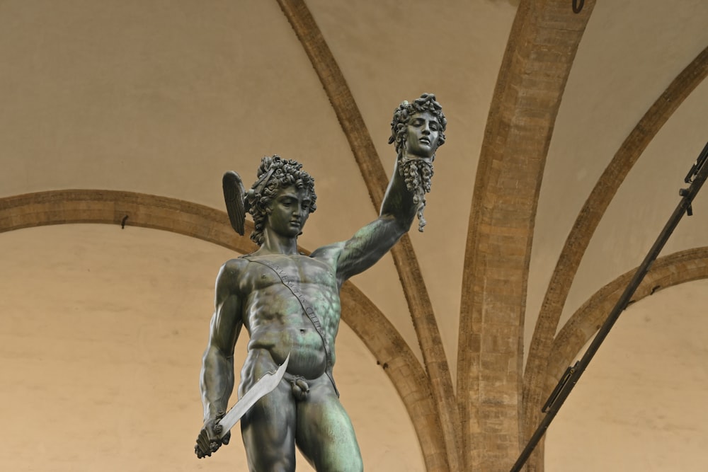 une statue d’une personne tenant un bâton