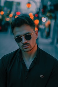 A vibrant photoshoot scene with a model wearing stylish glasses in an urban setting.