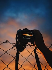 A cinematic shot of Enrique Blein Gerstl behind a camera, capturing a vibrant Miami sunset.