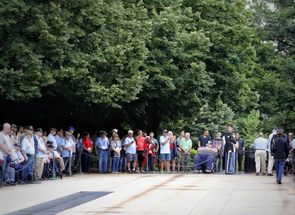 a group of people standing on a sidewalk