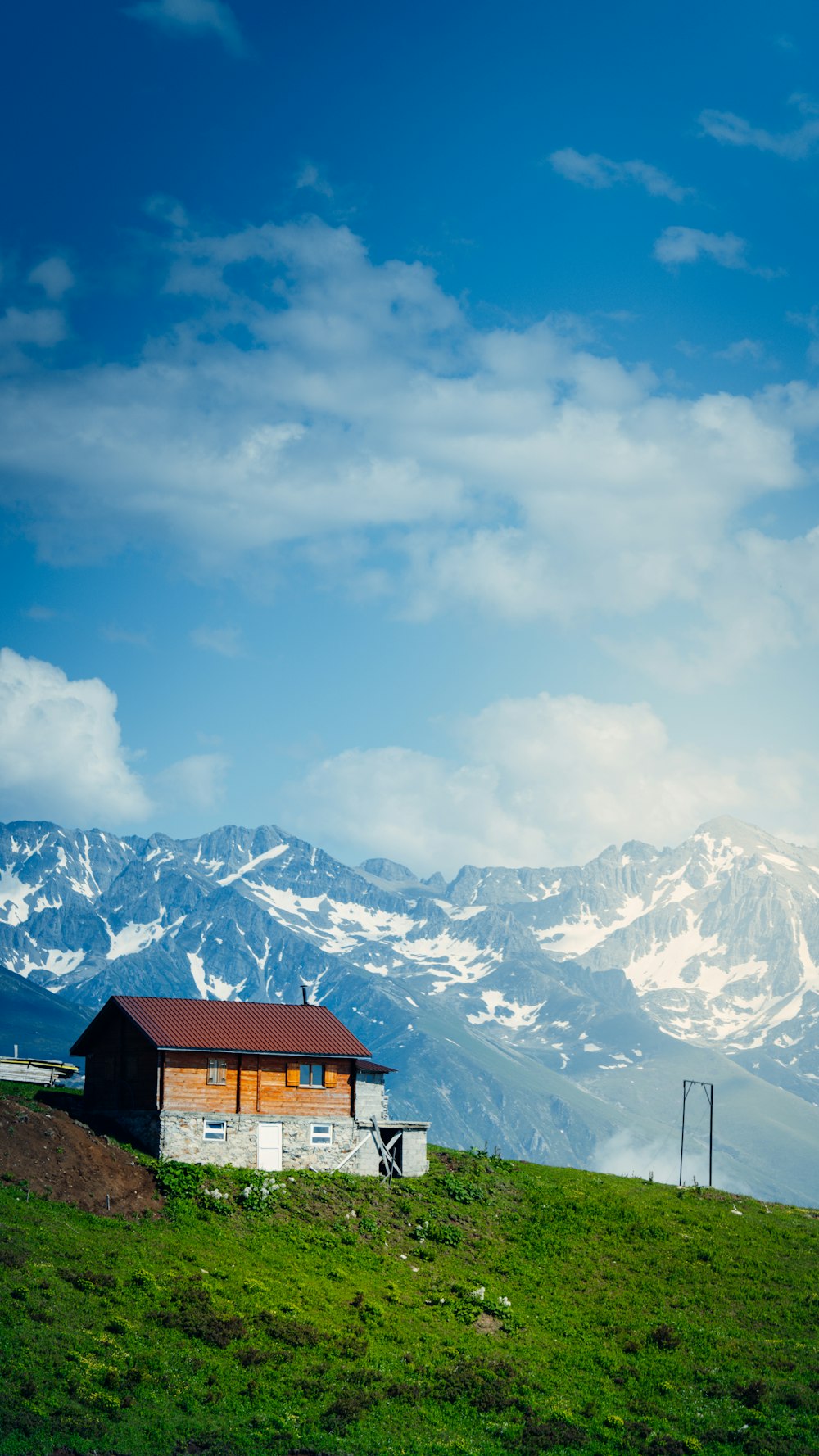 a house on a hill with mountains in the background