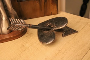 A heartfelt gift: a custom metal heart with engraved initials, finished in brushed silver, resting on a rustic wooden table.