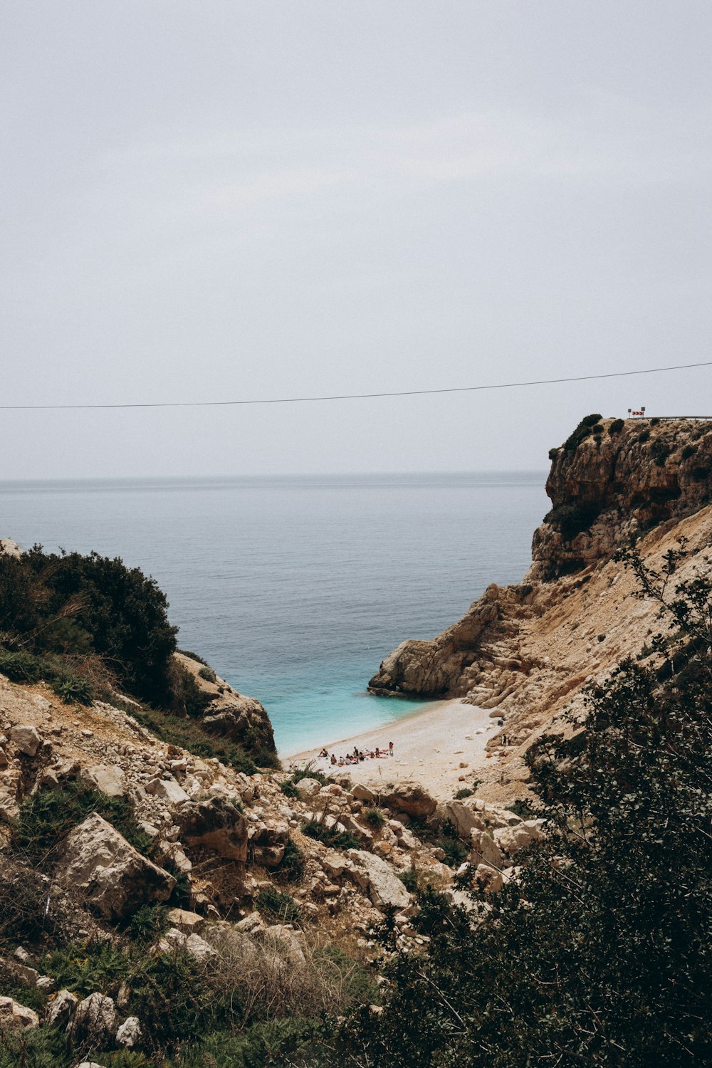 a rocky beach with a body of water in the background