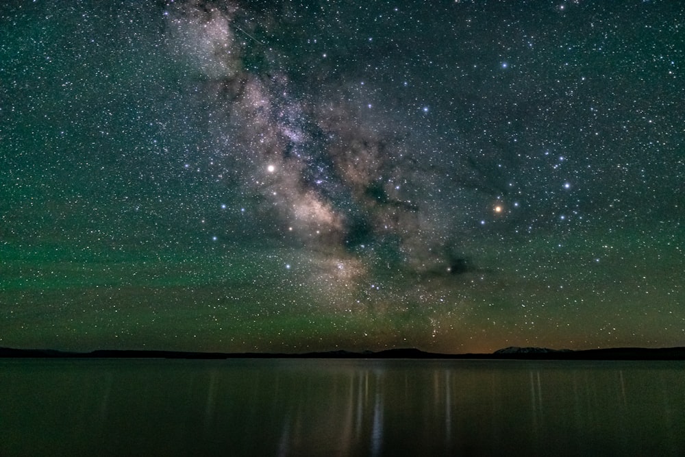 a green and purple sky over water