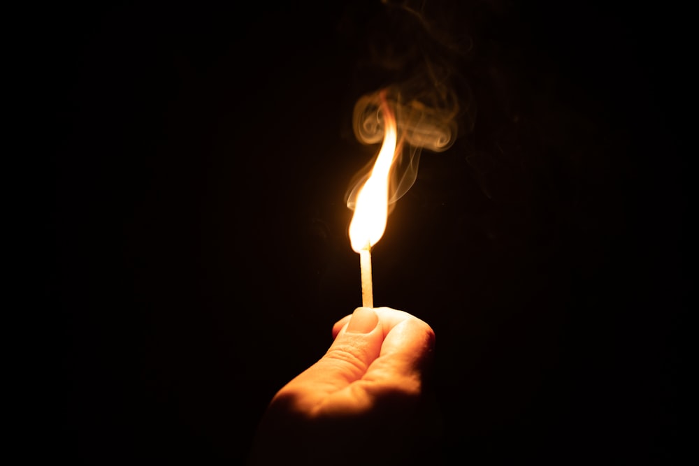 a person holding a lit match