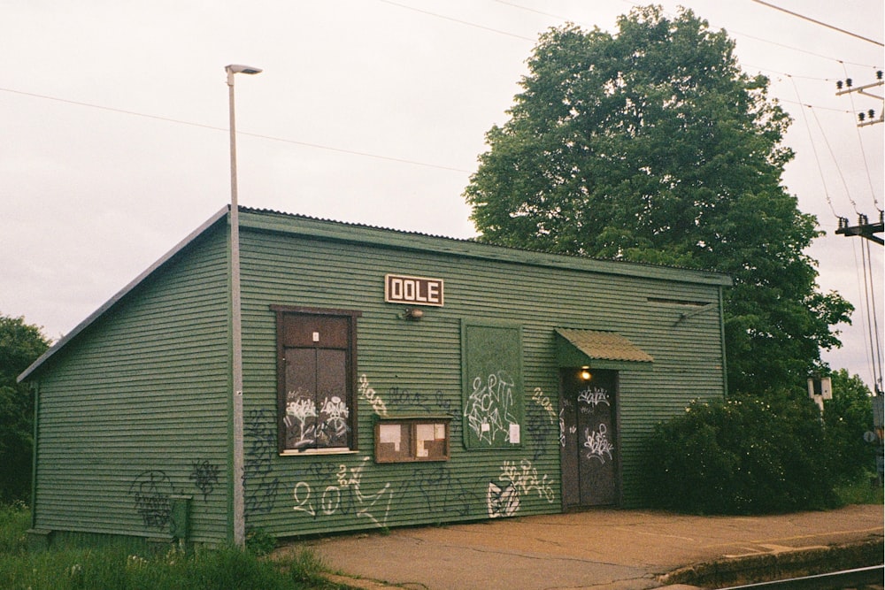 a green house with a tree in the front