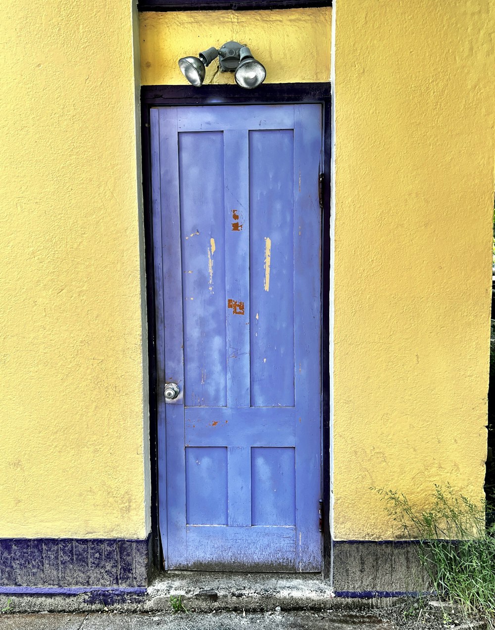 a blue door on a yellow wall