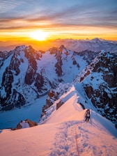 Runner ascending a rugged mountain trail at sunrise