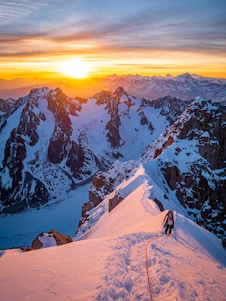 A person climbing a steep mountain path at sunrise, symbolizing perseverance and hope.