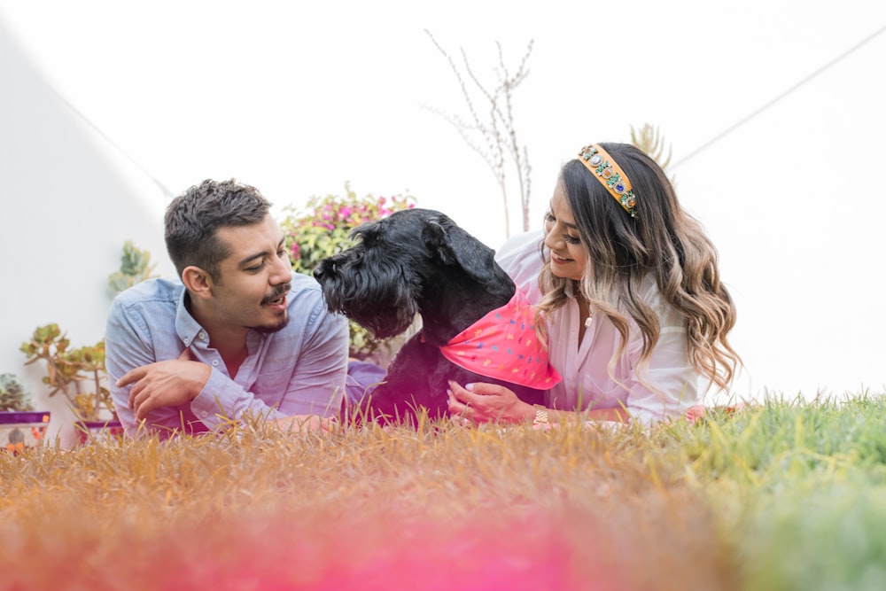 a man and woman holding a dog