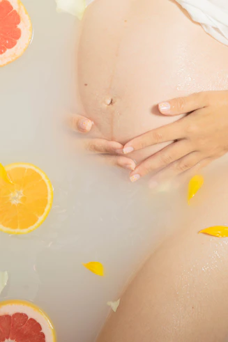 a pregnant person's hand touching a fruit