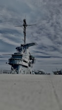 A naval engineer inspecting cargo damage on a ship deck under a bright sky.