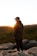 a man standing on a rock overlooking a forest
