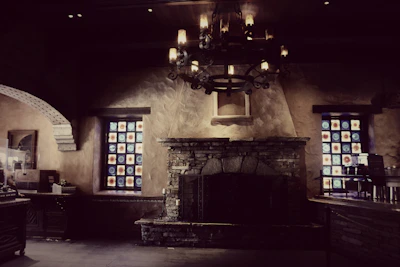 Rustic stone fireplace surrounded by comfortable seating and warm lighting.
