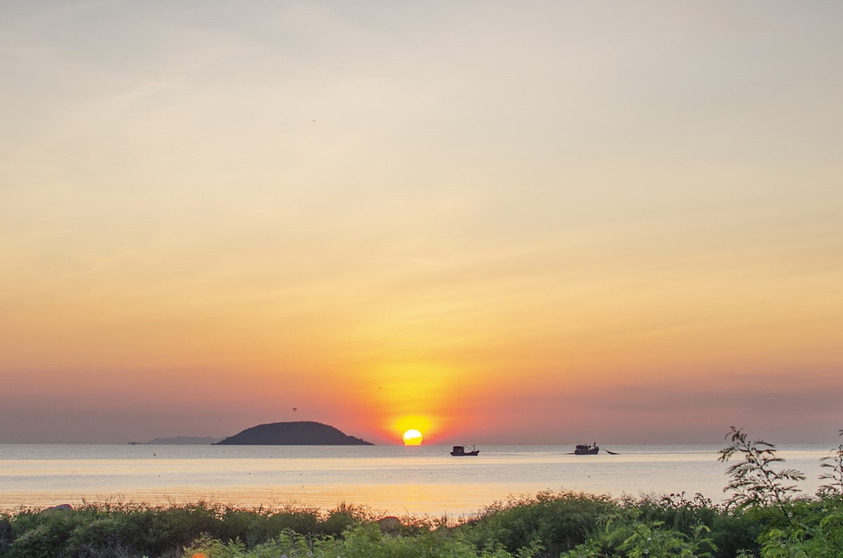 Mặt trời tan vào vịnh Nha Trang, những chiếc thuyền câu nhỏ in bóng trên nền trời hổ phách và hồng phấn — điểm kết vàng son của hành trình.