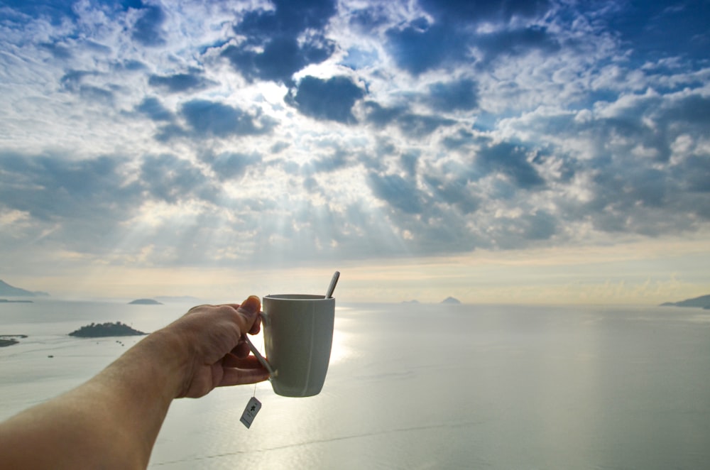 a hand holding a cup of coffee