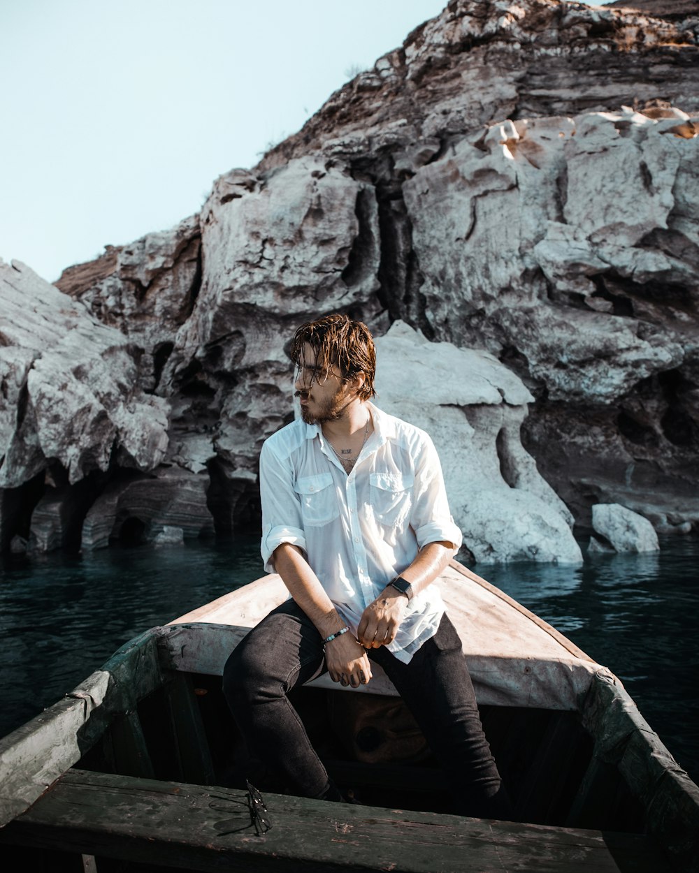 a man sitting on a dock by a body of water