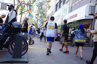 A lively street scene in Philadelphia with fans wearing sports jerseys near iconic landmarks.