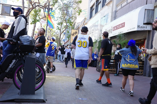 A lively street scene in Philadelphia with fans wearing sports jerseys near iconic landmarks.