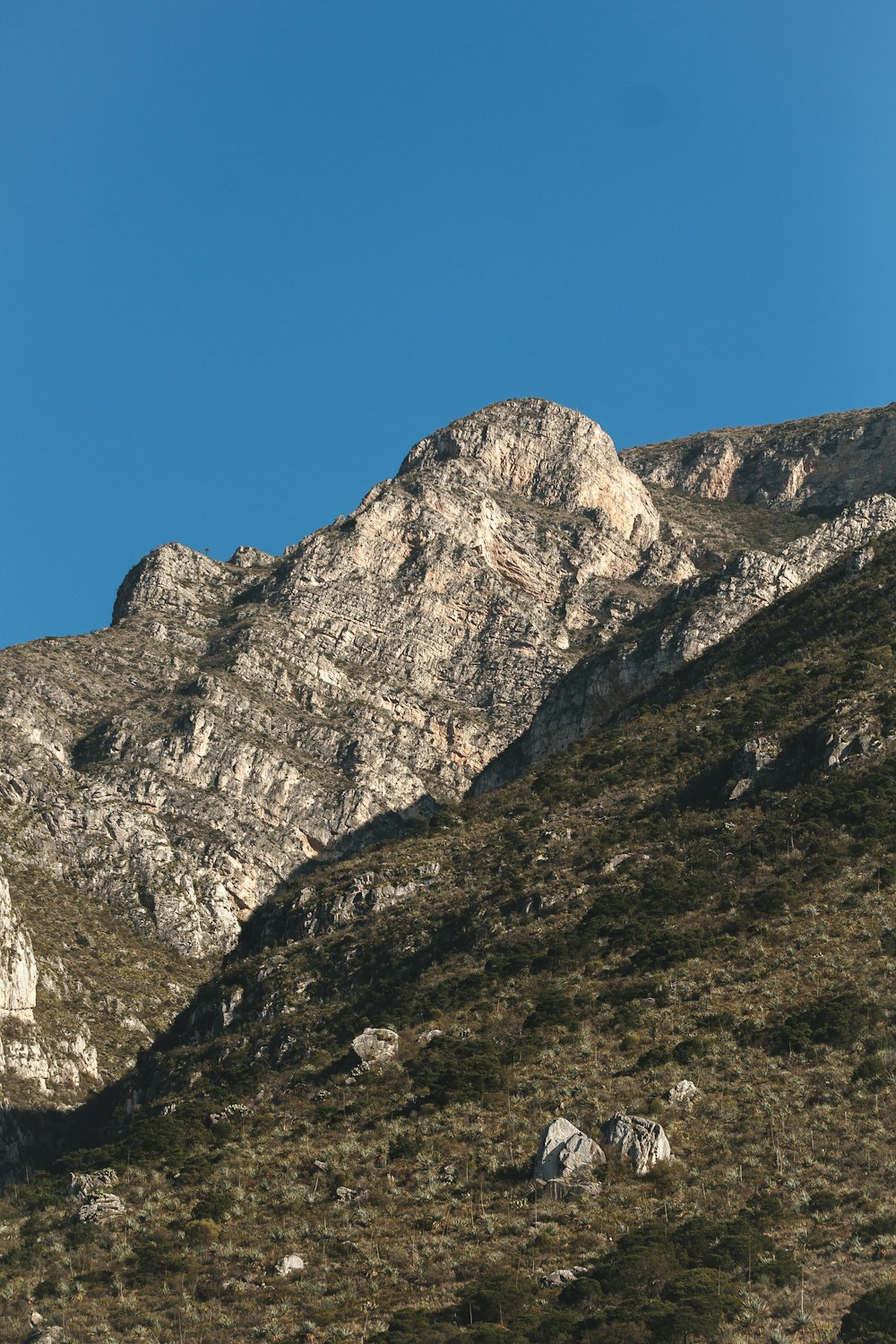 a rocky mountain with a blue sky