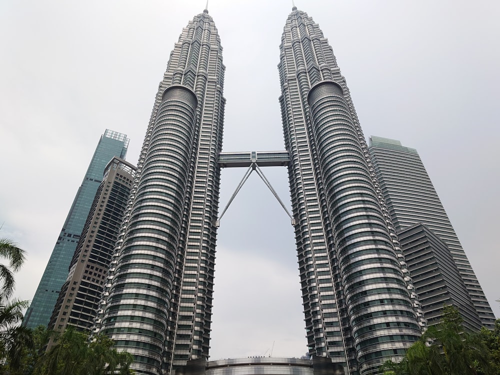 un par de rascacielos con las Torres Petronas al fondo