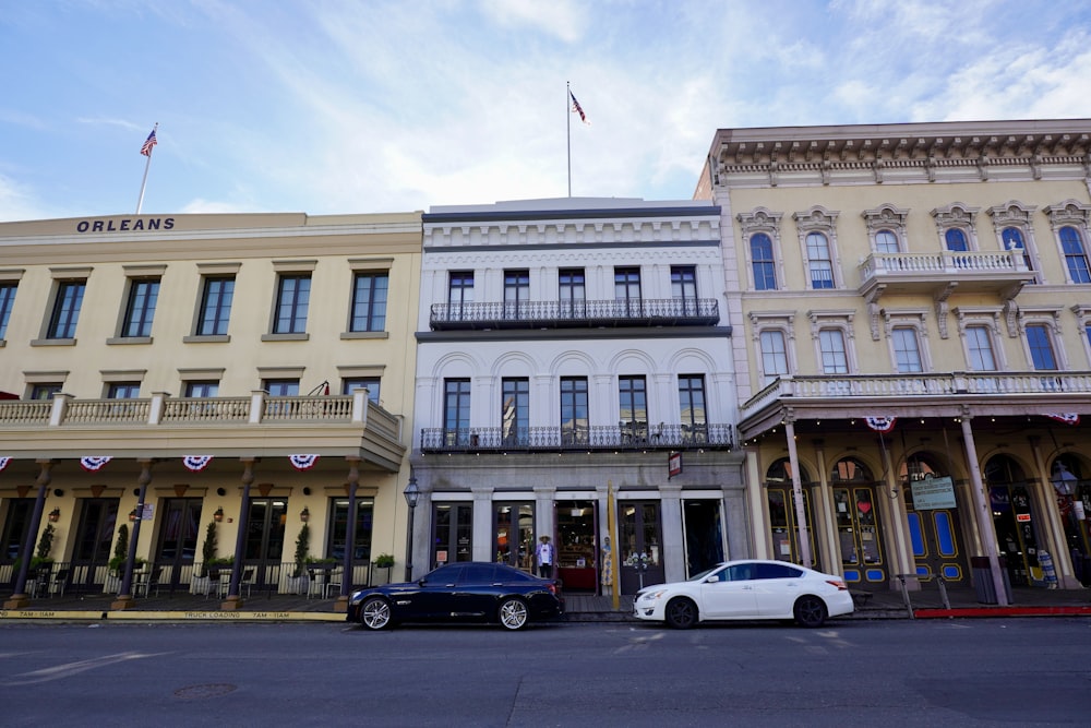 a couple of cars parked in front of a building with flags on top