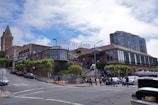 a street with cars and people on it and buildings in the back