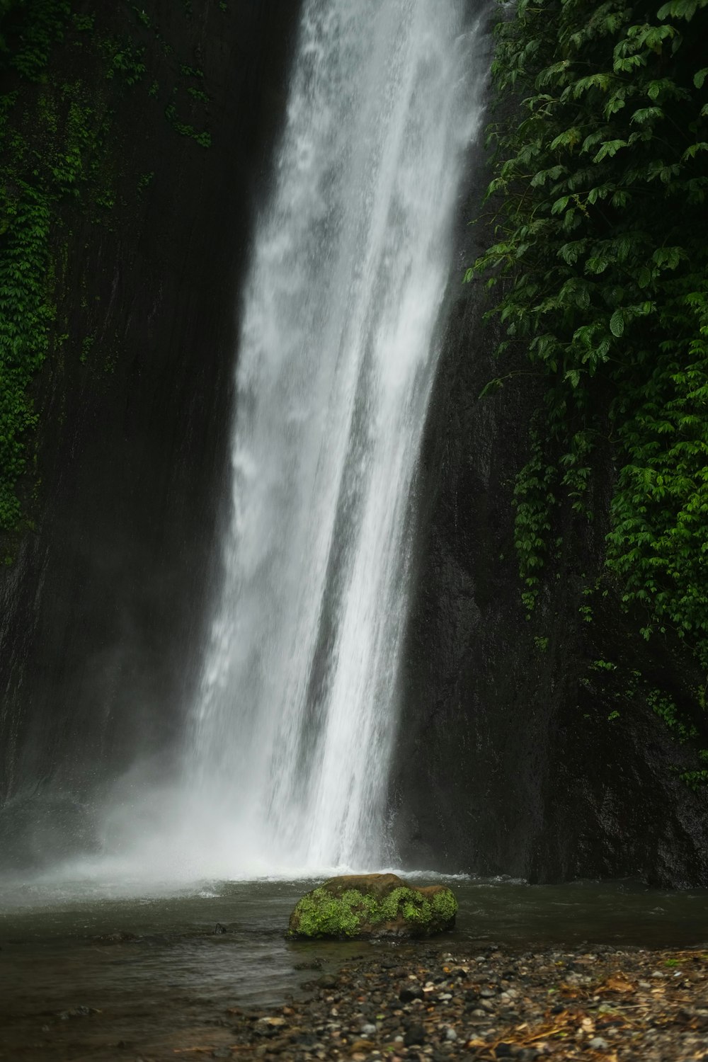 a waterfall with a rock in front of it