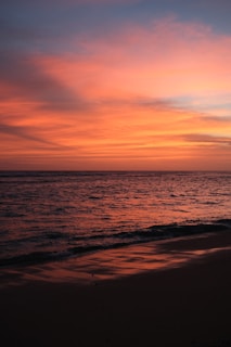 A breathtaking sunset over a serene beach with gentle waves.