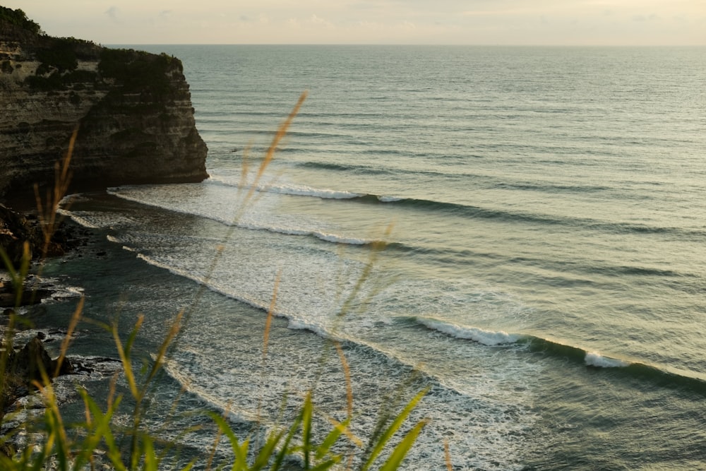 a beach with waves crashing against a cliff