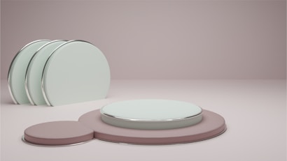 A minimalist composition featuring pastel-colored circular platforms. The foreground displays a large, teal circle layered on top of a larger, muted pink circle with a smaller pink circle adjacent. To the left, a set of three standing teal disks with metallic rims creates a sense of balance and symmetry.