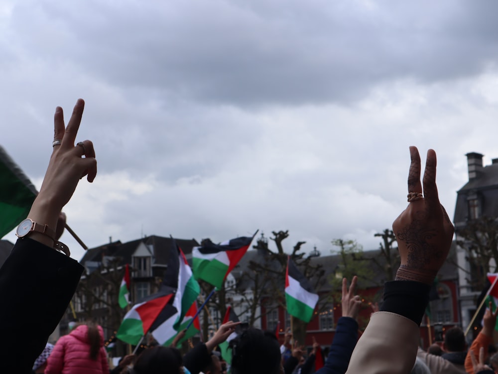 a crowd of people holding their hands up in the air