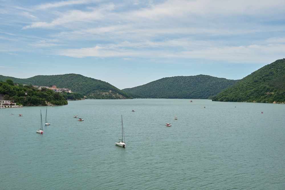 a body of water with boats in it and hills in the back