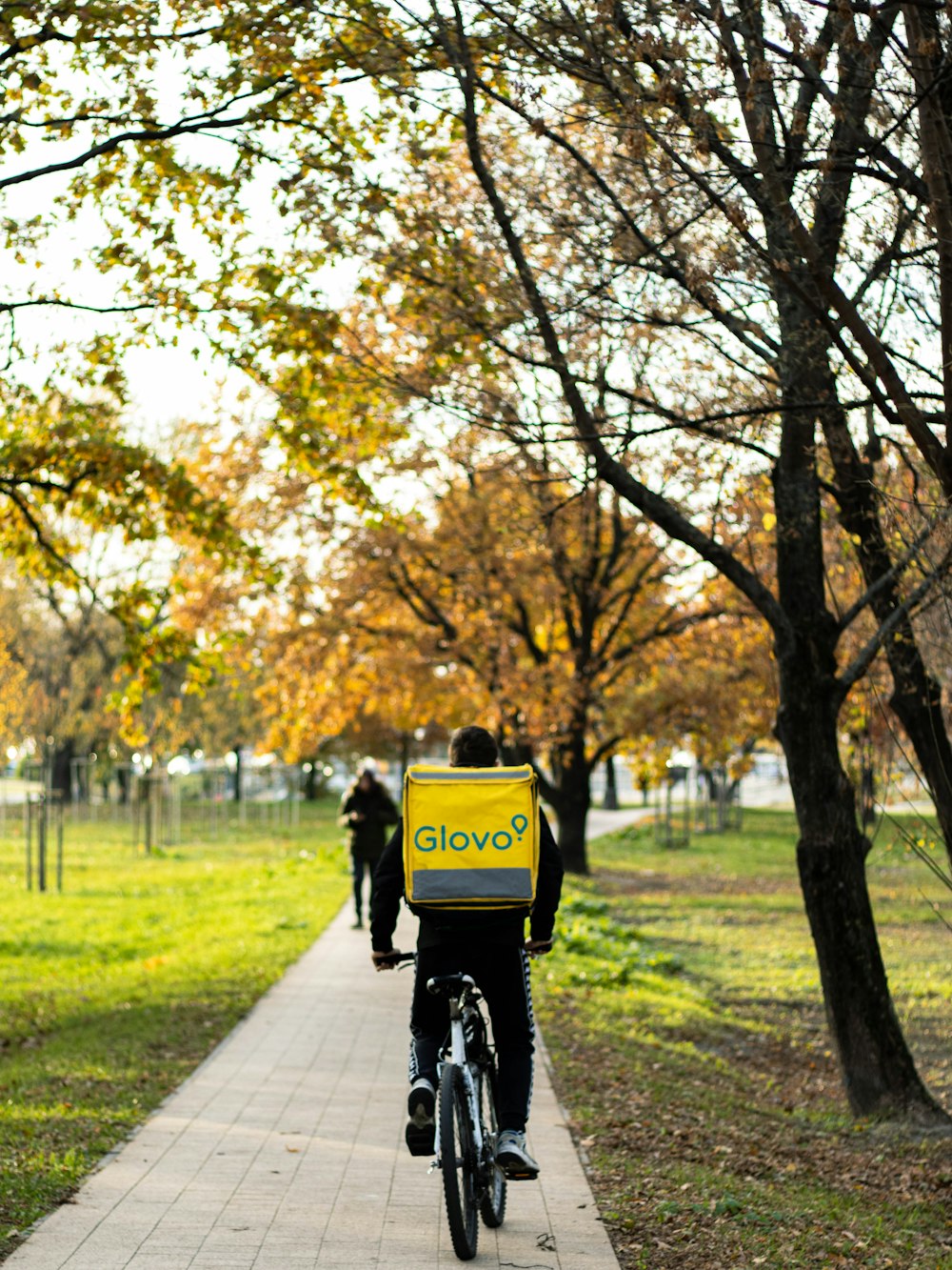 a person riding a bicycle with a sign on it