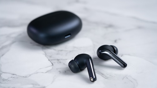 a black computer mouse and a black mouse on a white surface