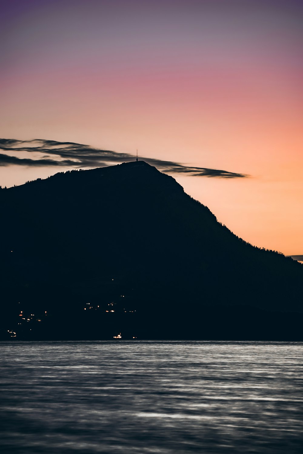 a large mountain with a body of water below