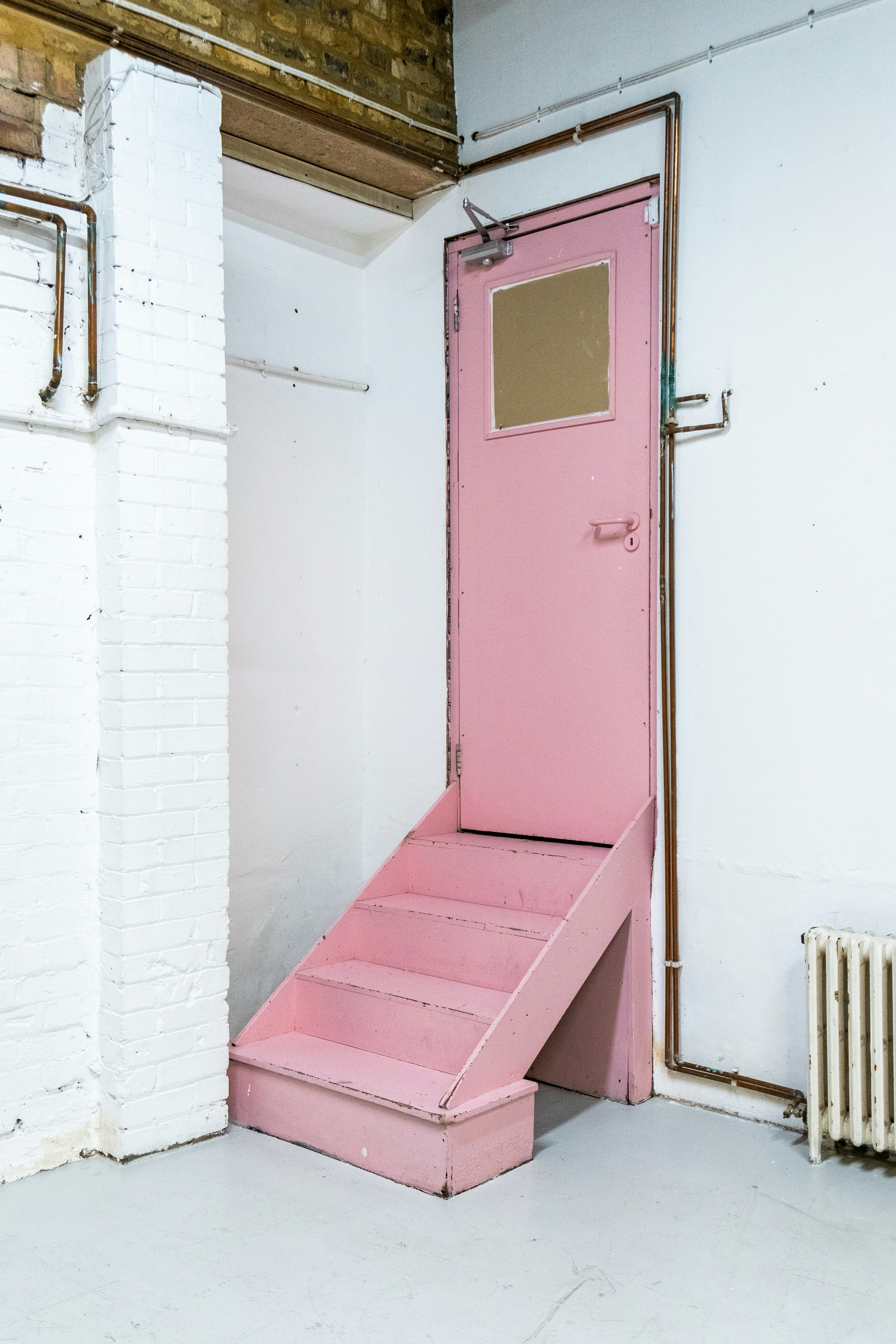 Una puerta rosa en un edificio blanco