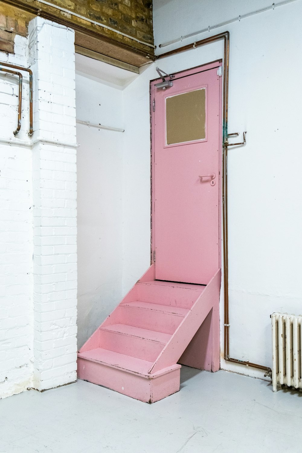 a pink door in a white building