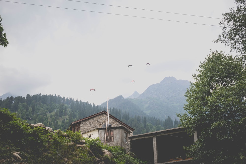 a house with a group of parachutes flying over it