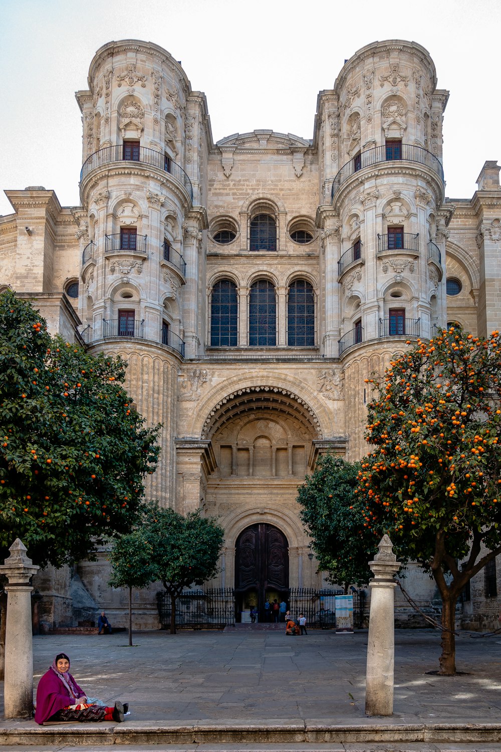 a person sitting on the ground outside of a large building